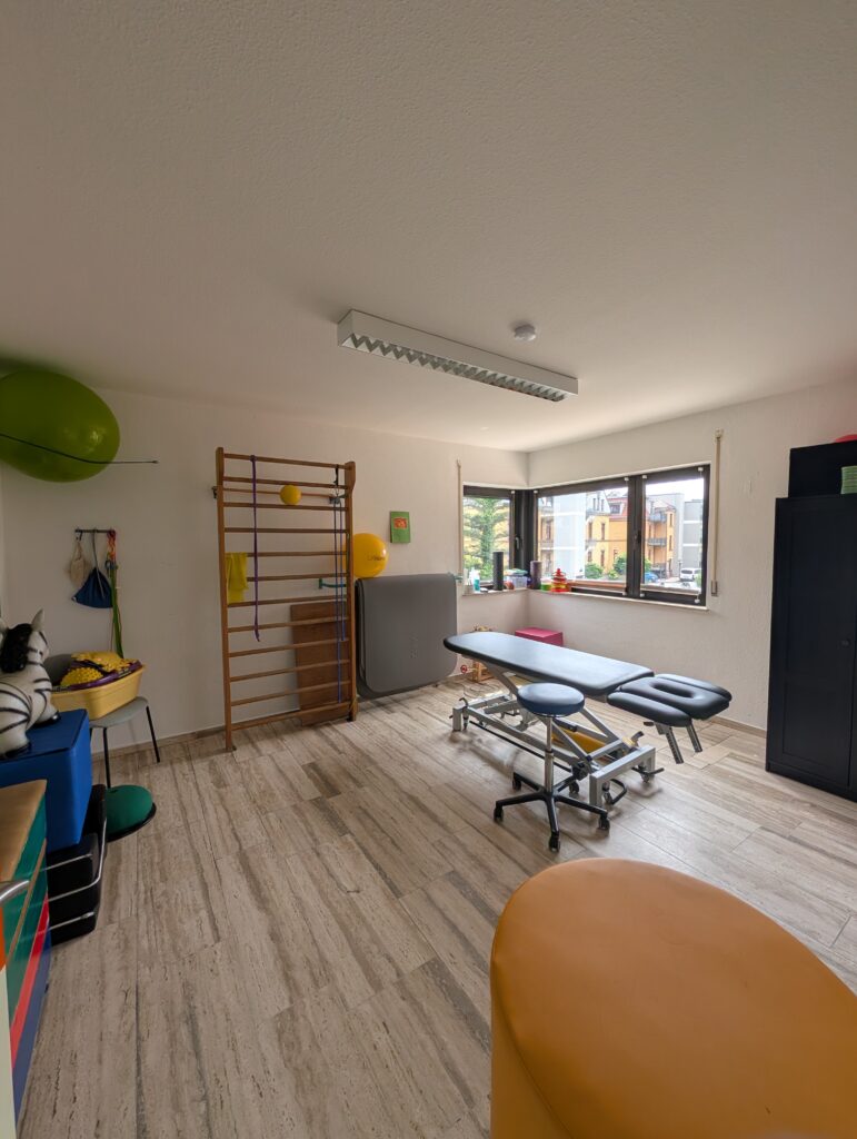 Therapieraum mit Behandlungsliegen, Sprossenwand und Gymnastikbällen